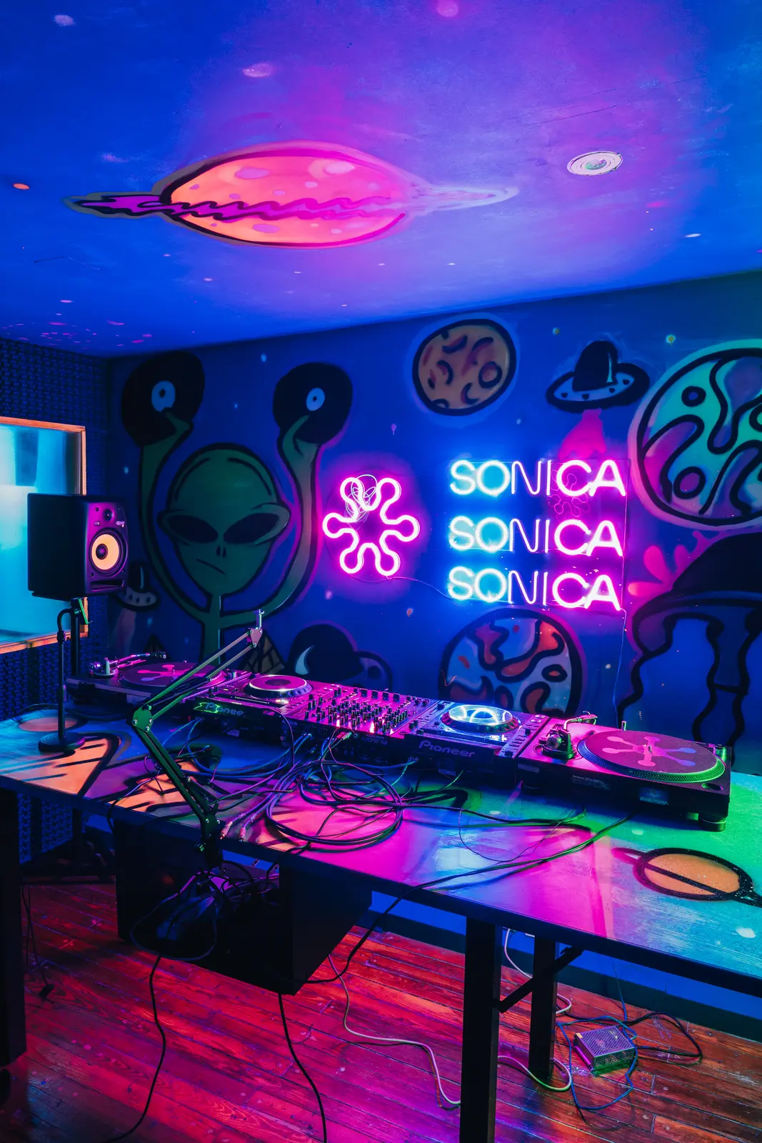 La cabina con los neones de Sónica y el mural de fondo