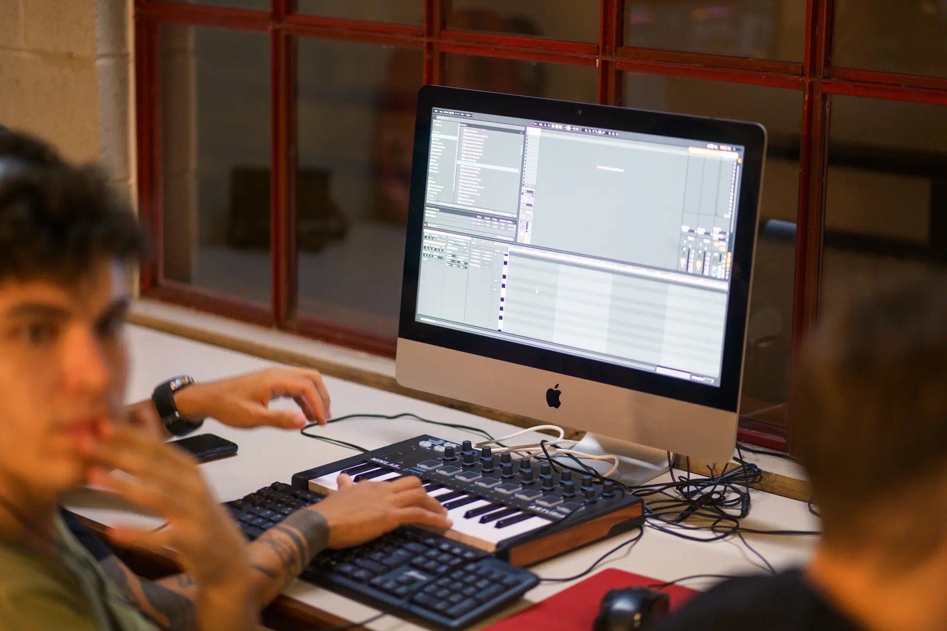 Un alumno toca el teclado MIDI frente a la computadora