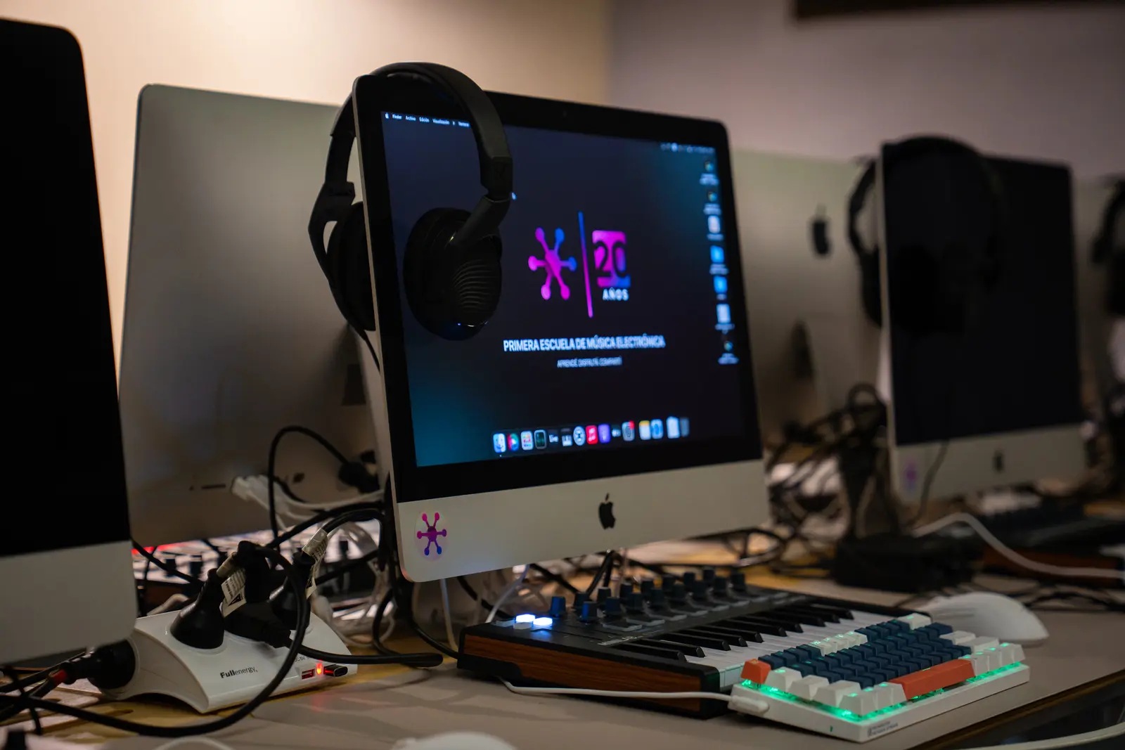 Un puesto del aula: computadora, auriculares, teclado MIDI y controlador