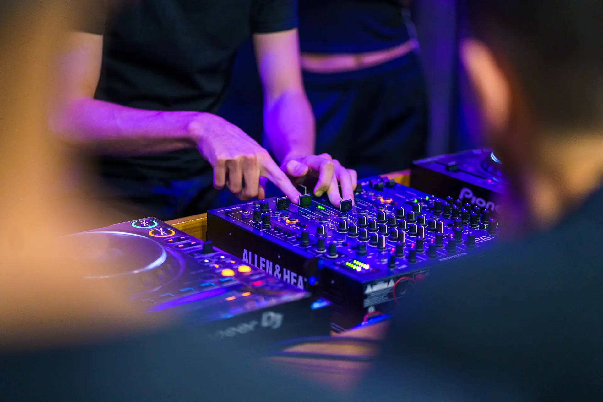 Manos sobre el mixer Allen & Heath durante una clase de DJ