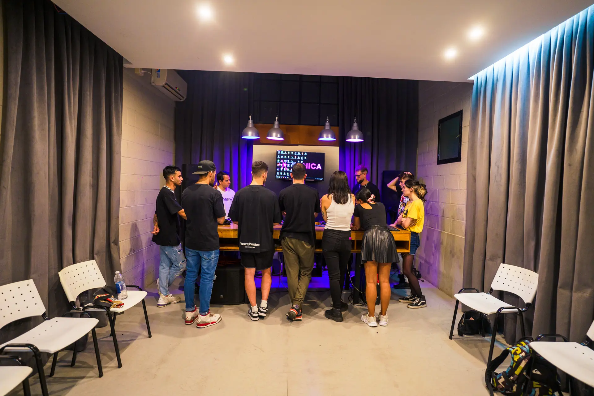 El aula de DJ con los alumnos de pie alrededor de la mesa de equipos