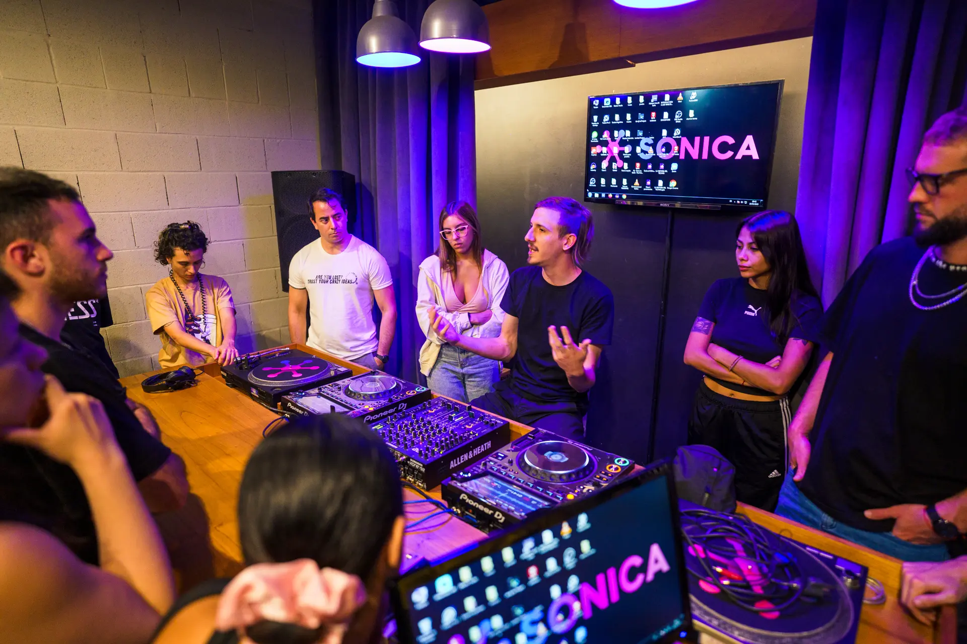 Ronda de alumnos en el aula de DJ, con las bandejas y los CDJ al frente