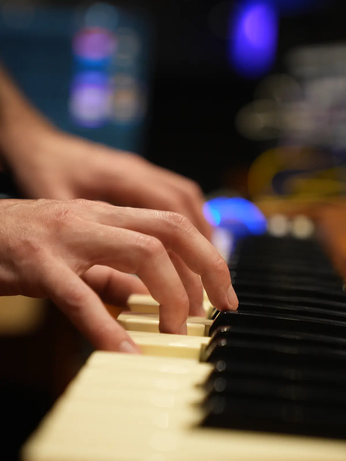 Manos tocando un teclado en el estudio