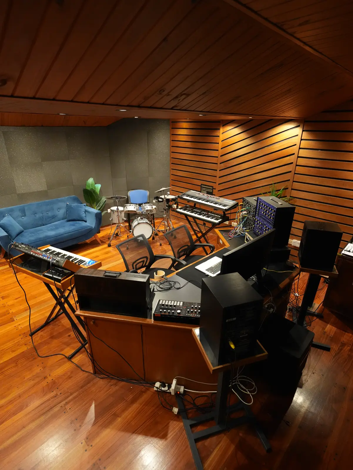La sala del estudio vista desde atrás, con la batería, los teclados y el sillón