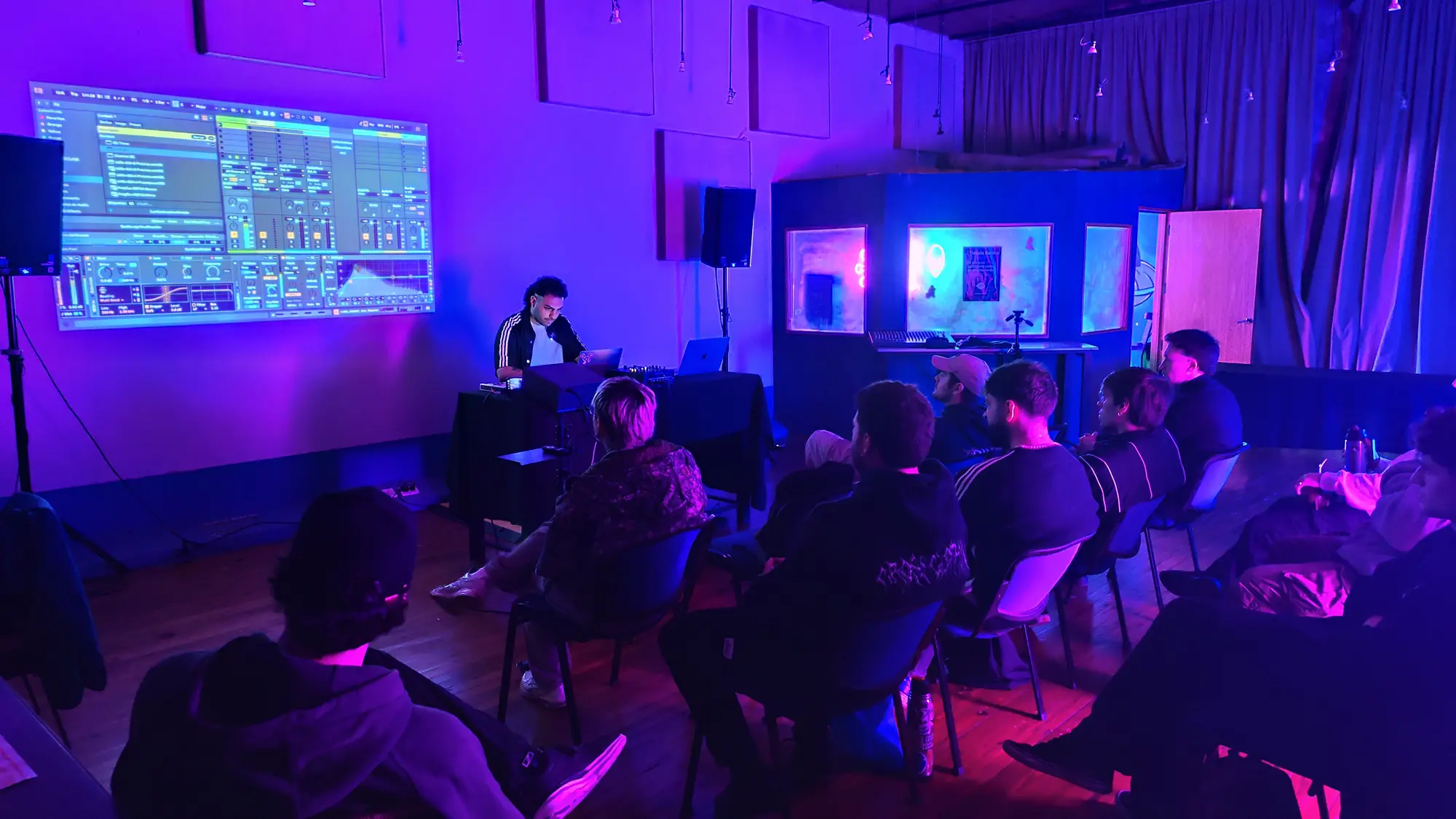 JXXXO dando la masterclass frente al grupo, con Ableton proyectado en la pared